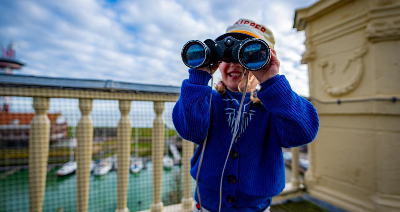 Meisje met verrekijker op panoramadak 